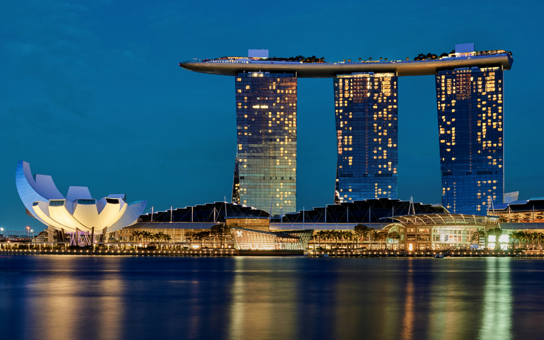 Sunset view of Marina Bay Sands skyline in Singapore with reflections on the water.