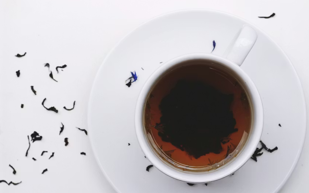 ngo-illustration-Artboard 5 Cup of black tea with loose tea leaves symbolizing Tasseography, intuition, self-discovery, and the art of tea leaf reading